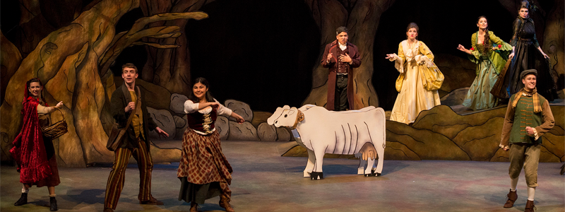 A group of several expressive people wearing renaissance-style clothing. They are big trees with large roots and a cow nearby.