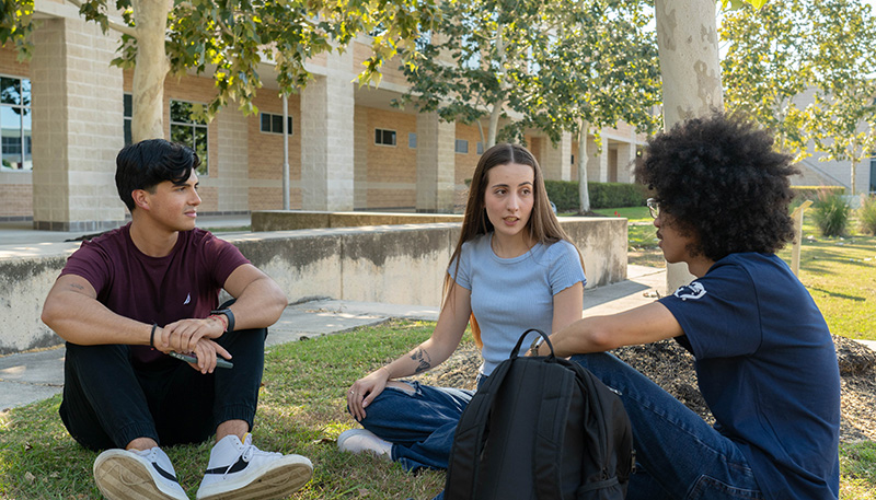 Students sitting outdoors on LSC-CyFair campus and talking