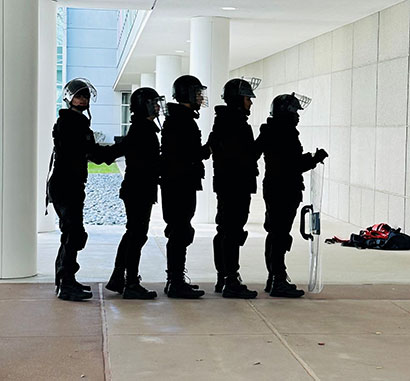 A team of students, clad in tactical gear, stands poised and ready Lone Star College-University Park, Feb. 24, 2024, for the TXPSTA High School First Responders State Competition, eager to demonstrate their skills.   