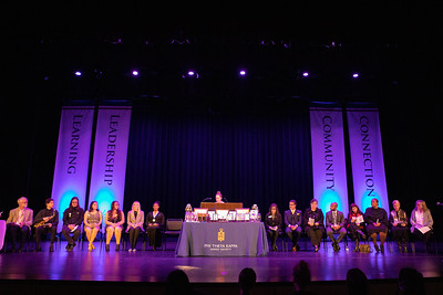 Phi Theta Kappa induction ceremony is held in the PAC each year. Dramatic blu lights shoot up on either side of a table arranged with awards.
