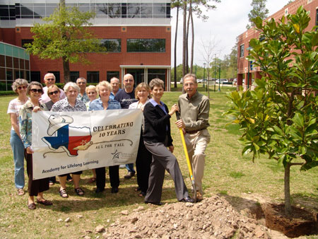 Helen Bostock, chair of the Academy for Lifelong Learning (ALL) at Lone Star College-Montgomery, shovels dirt with Tim Welbes, co-president of The Woodlands Development Company, during the planting of a magnolia tree in honor of ALLs 10th anniversary. Past chairs and ALL members look on during the ceremony, which was generously underwritten by The Woodlands Development Company.