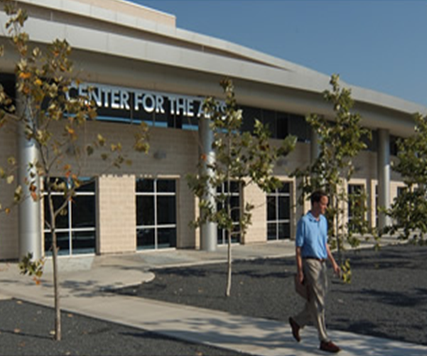 Photo of the Center for the Arts building with a man walking in front.