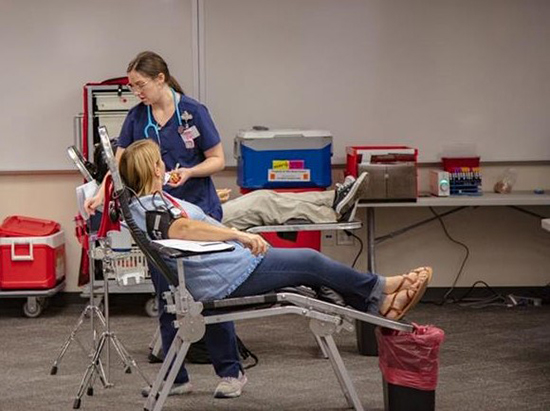 A donor participates in the LSC-University Park blood drive, overseen by a Gulf Coast Regional Blood Center representative, as part of a concerted effort with UHD-Northwest to "Sock it to Cancer" in honor of Childhood Cancer Awareness Month.