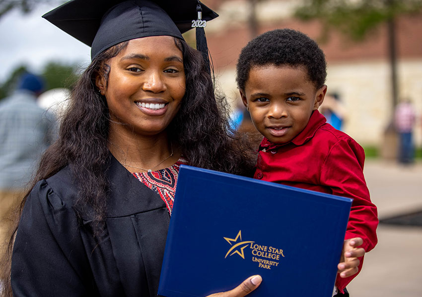 LSC-UP graduate holding child and degree