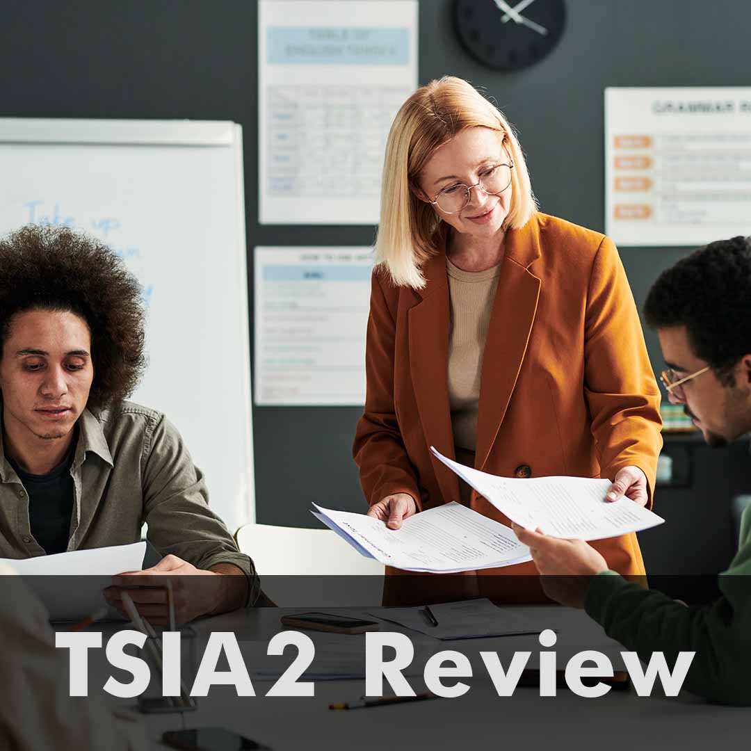 The words TSIA2 Review are written across the bottom of the image as a header. One woman passing out paperwork to a man. A second man is reviewing work.