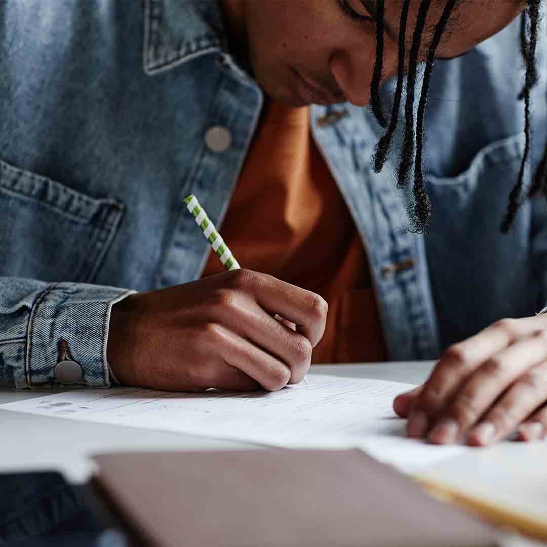 A man writing on a sheet of paper.