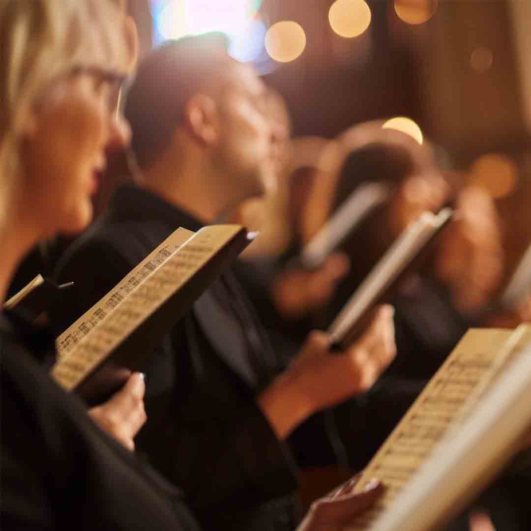 People singing, holding sheet music