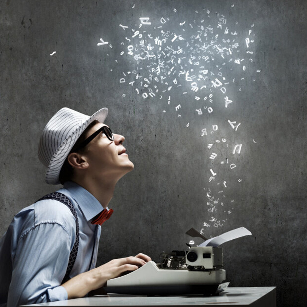 Man typing on typewriter with magical letters floating in the air.