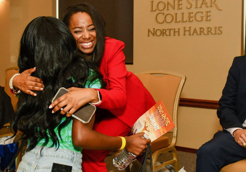 student and employee hugging