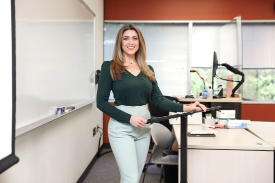 Marcela Prez Barros standing at a podium in a classroom