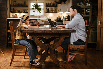 Daughter and mother sitting at kitchen table