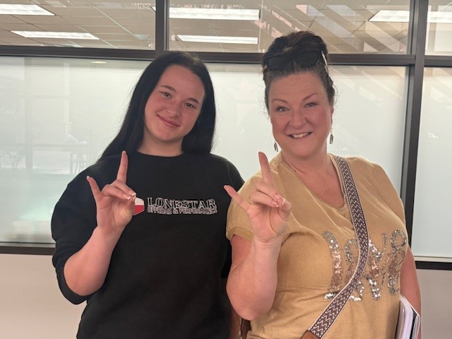Mom and daughter at Engage Week showing school spirit with hand sign